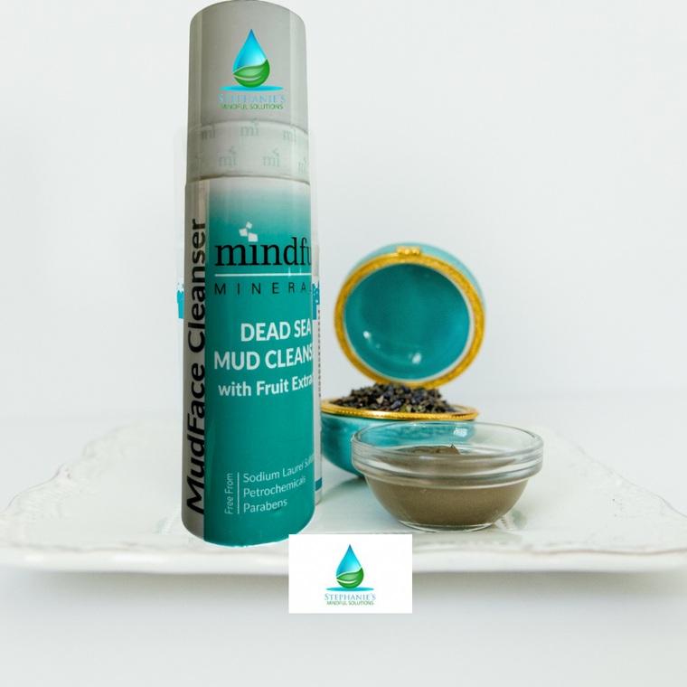 Mud face cleanser bottle with a bowl of mud on a white background